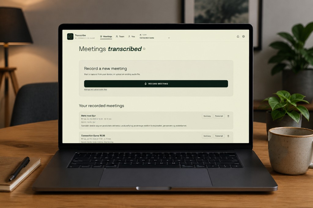 Laptop på et skrivebord som viser Transcribe-grensesnittet med møteliste og opptaksknapp